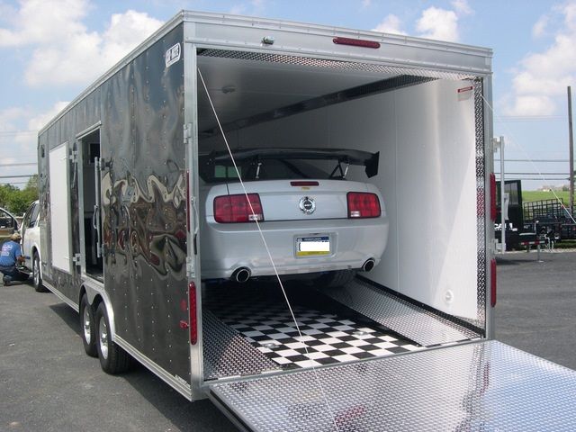 an enclosed car trailer with a ford mustang on board