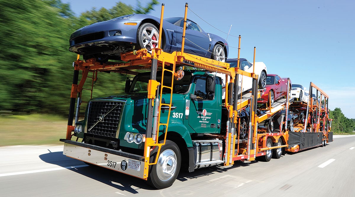 an open car trailer with exclusive cars on board